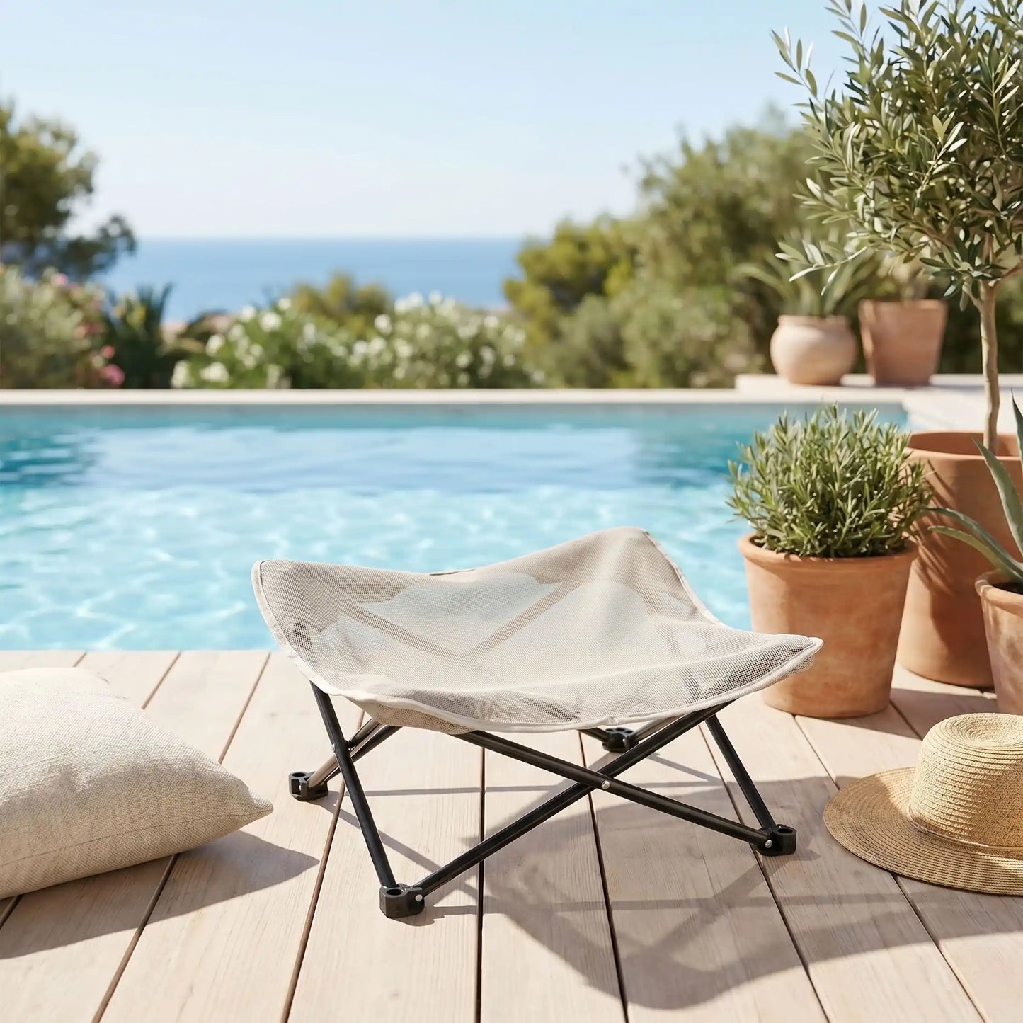Fauteuil-pour-petit-chien-camping-chaise pour chien beige ou noir, lit de camp carré avec tissu déhoussable imperméable et lavable, en maille respirante pour un lit rafraichissant en été structure en acier inoxydable solide et pliant pour une utilisation partout en intérieur et extérieur pour chiot et chien de petite race de 0 à 5 kilos- gros plan sur la chaise d'été en toile imperméable et pieds surélevés en inox pour chien de couleur beige sur la terrasse de la piscine en été
