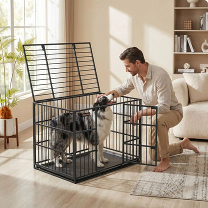 Cage-chien-interieur-chiot-xl en acier noir robuste avec 4 verrous, deux porte sur le toit et le devant pour le chien, plateau en fond amovible ramasse saleté pour un nettoyage facile et rapide gilles intérieur adapté aux chiens à pattes courtes, rectangulaire pour chiot et chien de moyenne à grande taille juqu'à 40 kg-un Berger australien   tout heureux dans sa cage sécurisé avec le toit ouvert par lequel son maitre le caresse avec affection pour un apaisement dans le salon de l'appartement