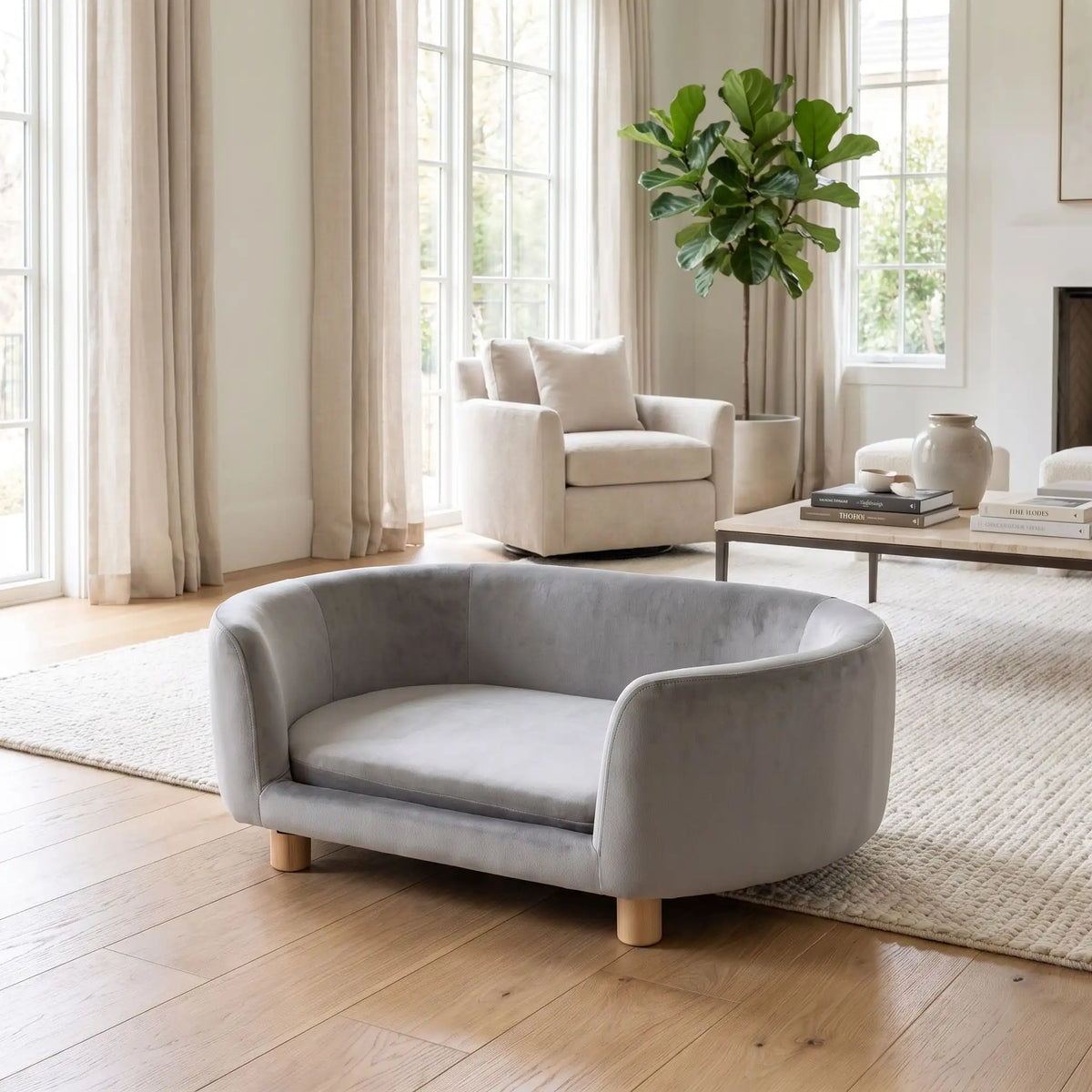 Canapé gris pour chiot et chien, structure en bois de bouleau , dossier haut et entourant à 360° au design moderne et arrondi avec son coussin en éponge 100% coton haute densité et ergonomique déhoussable et lavable en machine, housse en velours douce et résistante, sur pied en bois massif pour chien de petite taille- gros plan sur le canapé ergonomique au design moderne et scandinave de couleur gris dans un appartement haussmannien lumineux