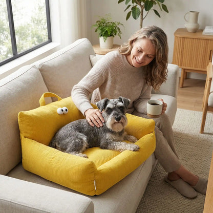 Canape-lit-chien-apaisant, mini fauteuil en lin et rtembourrage épais 100% coton haute densité, avec accoudoir et dossier ergonomique, lavable en machine, antidérapant et fond imperméable anti-moissisure, housse 100% lin résistant aux griffes et respirant pour un couchage 4 saisons pour chiot et chien de petite taille de 0 à 10 kilos max-un schnauzer nain couché confortablement dans le petit canapé de couleur jaune sur le canapé à côté de sa maitresse assise qui le caresse en buvant son café dans le salon