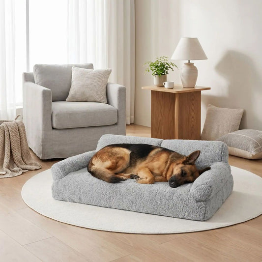 Canapés-pour-chiens-xxl-120-cm, déhoussable, antidérapant et lavable en machine, en peluche éponge douce et rembourrage 100% coton haute densité, housse 100% imperméable, avec 2 dossiers et 2 accoudoirs pour chien de 0 à +40 kg- un berger allemand qui dort couché sur le canapé xxl pour chien et chiot de grande race de couleur gris dans le salon de l'appartement