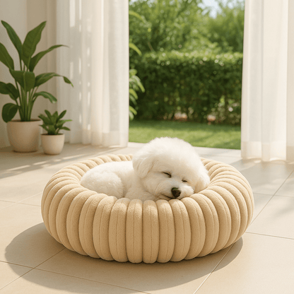 Coussin-anti-stress-chien-chiot-lavable en machine-rembourrage 100% coton haute densité-ergonomique-épais-antidérapant-housse ultra-douce en velours-résistant aux griffes-design-un petit chien blanc qui dort confortablement et heureux dans son lit rond , sa tête soutenu par le rebord surélevé entourant à 360° et sécurisant anti-anxiété pour chien de petite taille de couleur beige sur le sol du salon de la maison