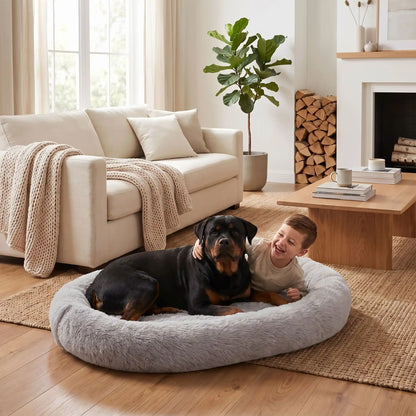 Coussin-chien-xxl-déhoussable-avec-rebord-orthopédique, matelas à mémoire de forme et rebord cylindrique surélevé 360° anti anxiété , rembourrage 100% coton PP, lit ovale en peluche, imperméable, antidérapante et lavable en machine, taille humaine pour cododo avec le chien de 176x122 cm ou couchage multi-animaux-un garçon et un chien de grande race allongé confortablement dans le grand coussin gris ultra doux avec poches de rangement sur le boudin et poignée de transport dans le salon de la maison