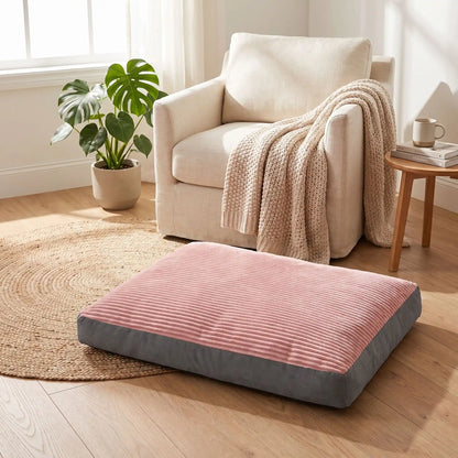 Coussin-déhoussable-pour-chien-chiot-matelas rectangulaire épais, rembourrage 100% coton haute densité ergonomique, totalement déhoussable et lavable en machine, housse en velours côtelé doux et résistant au griffes et morsures, fond imperlméable et antidérapant,transportable et léger en 3 tailles L, XL et XXL pour chien de toute tailles jusqu'à 45 kg max-gros plan sur le coussin épais design rose et gris sur le sol du salon de l'appartement pour chiot et chien de petite à grande taille