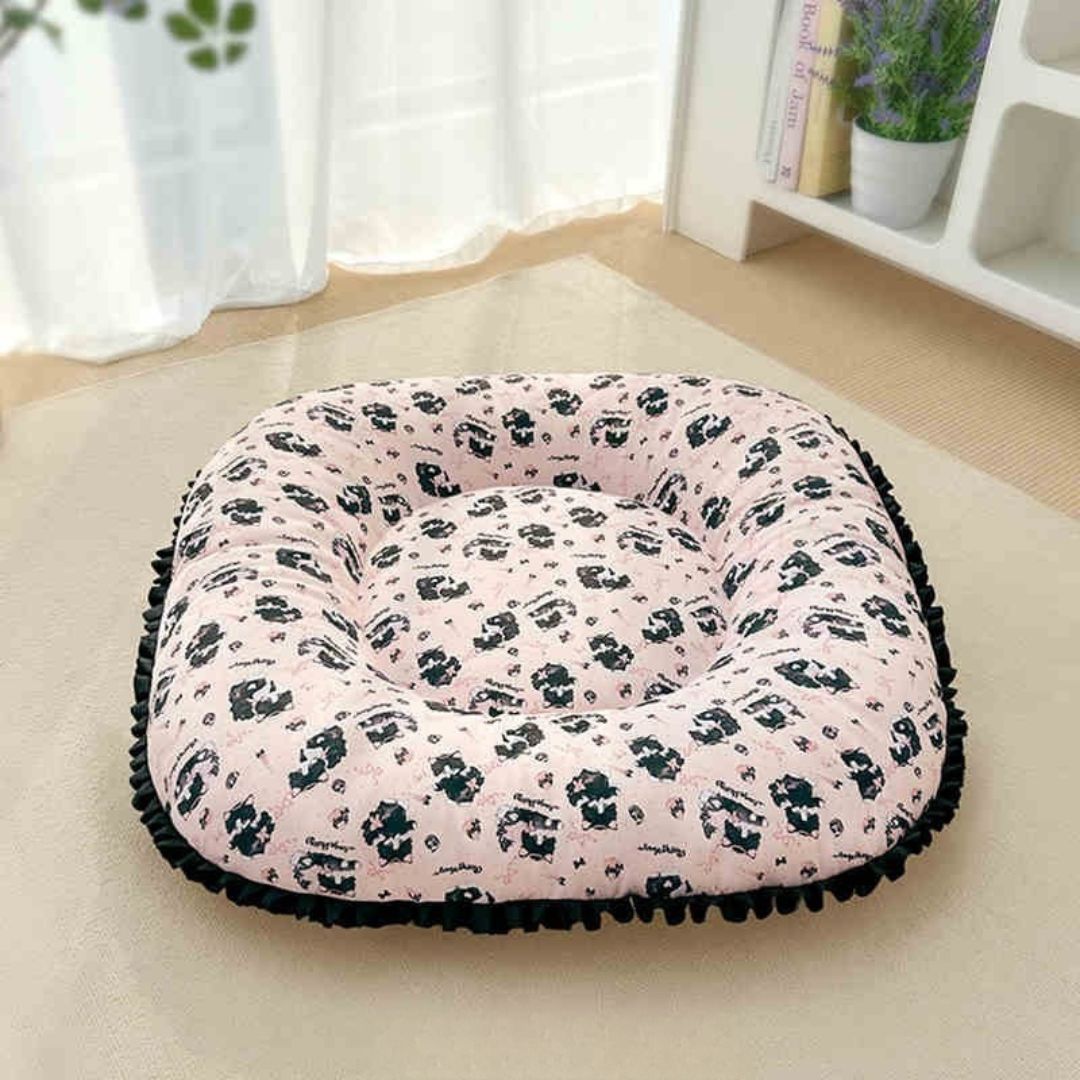 Coussin-petit-chien-chiot-cosy-avec rebord 360° entourant surélevé pour envelopper et avoir un effet anti-anxiété, rembourrage 100% coton haute densité, tissu 100% imperméable, lavable en machine, de forme carré pour une utilisation polyvalente ou donner plus de confort au couchage, en 3 tailles XS, S et M pour chiots et chiens de 0 à 9 kg-gros plan qur le coussin épais ergonomique de forme carré avec rebord large et entourant sur tout le coussin de couleur rose et noir sur le sol du salon de la maison