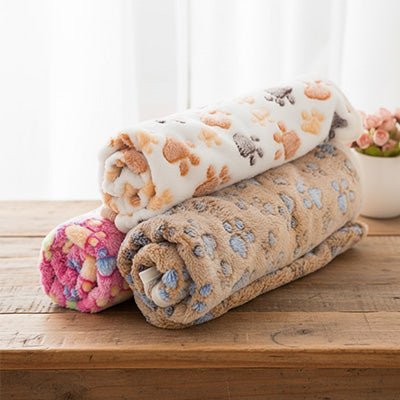 Couverture-pour-chien-design-pattes-de-chien-tissu corail toucher velours ultra-doux-coutures résistante et imperméable-lavable en machine pour chien de toute taille-4 couleurs disponibles bleu, rose, marron et violet en 2 tailles M et L