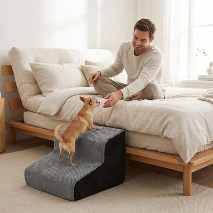 Escalier-mousse-pour_chien-chiot-antidérapant, déhoussable lavable en machine avec mousse haute résilience à mémoire de forme pour protèger les articulations sensibles, sécurisé , confortable, résistant aux griffes pour petit et chien de moyenne taille-un chihuahua qui monte confortablement sur l'escalier de 2 marches en mousse gris et noir pour rejoindre son maitre sans le lit en toute sécurité