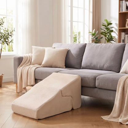 Escalier-pour-chien-2-en-1- transformable en rampe douce-en-mousse- tissu antidérapant, déhoussable et lavable en machine, éponge coton haute densité et élasticité qui absorbe les chocs, protège les articulations et la colonne vertébrale, léger et transportable, adapté au chiot et chien de race petite à moyenne, disponible en 3 couleurs beige, gris clair et gris foncé-gros plan sur l'escalier en version pente douce  de couleur beige contre le canapé dans salon de l'appartement