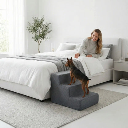 Escaliers pour chien et chiot antidérapant, déhoussable lavable en machine avec mousse haute résilience à mémoire de forme pour protèger les articulations sensibles, sécurisé , confortable, résistant aux griffes pour petit et chien de moyenne taille-design velours sur le dessus ultra-doux et tissu en coton solide-un chien de race naine et paytes courtes qui monte sur l'escalier de 3 marches en mousse pour rejoindre en toute sécurité sa maitresse qui l'appelle couché dans son lit