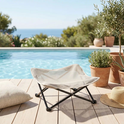 Fauteuil-pour-petit-chien-camping-chaise pour chien beige ou noir, lit de camp carré avec tissu déhoussable imperméable et lavable, en maille respirante pour un lit rafraichissant en été structure en acier inoxydable solide et pliant pour une utilisation partout en intérieur et extérieur pour chiot et chien de petite race de 0 à 5 kilos- gros plan sur la chaise d'été en toile imperméable et pieds surélevés en inox pour chien de couleur beige sur la terrasse de la piscine en été