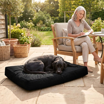 Housse-coussin-chien-100% imperméable-5-tailles S, M, L, XL et XXL-lavable en machine- anti-poils-antistatique-antibactérien-protection ultra-résistante en tissu Oxford 250 D résistant aux griffes et morsures de couleur noir-protection de couchage, coussin, lit, matelas, panier de forme rectangulaire-un chien de grande race couché confortablement sur la housse douce et hypoallergénique et hygiénique xl qui protège son matelas sur le sol de la terrasse de la maison au pied de sa maitresse qui déjeune dehors