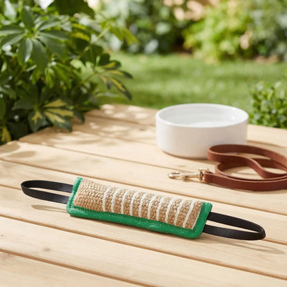 Jouet-indestructible-chien-interactif-coton-lin pour jeu de traction, de rermorqueur, de tir à la corde, avec deux sangles aux extrémité et boudin doux et résistant aux morsures et machoires puissantes-gros planc sue le jouet en forme de boudin pour des jeu éducatif canin de couleur verte sur la table de la terrasse de la maison