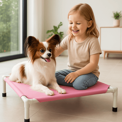 Lit-de-camp-chien-sur pied-en acier-respirant-résistant aux griffes-lavable en machine-transportable-démontable sans outils-pliable-multifonction-lit-surélevé pour petit chien et chiot-de couleur rose-petit chien couché sur son petit lit surélevé avec une petite fille assise à côté de lui dans le salonde la maison