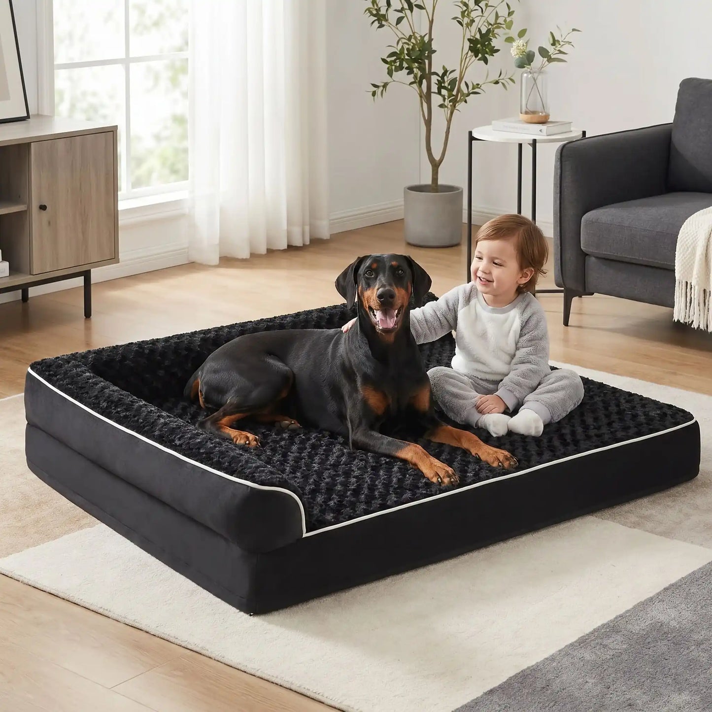 Lit-pour-grand-chien-orthopédique-xxl avec traversin intégré,antidérapant-imperméable-déhoussable-lavable en machine-résistant aux griffes et morsures  pour grand chien et chiot jusqu'à 50 kg max-en velours côtelé et 100% Coton PP et deux traversins cylindriques rembourré en forme de L de couleur noir pour un effet apaisant et sécurisant-un grand chien et un petit garçon assis qui le caresse tendrement sur le lit orthopédique en velours et peluche résistant et déhoussable de couleur noir avec liseret blanc