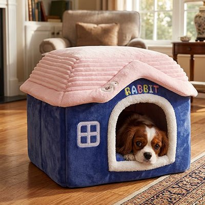 Maison-interieure-pour-chien-chiot-lavable, antidérapant, pliable avec toit, déhoussable et lavable en machine avec son coussin intérieur amovible au rembourrage 100% coton haute densité pour chiot et chien de petite race et petite taille de 0 à 4 kilos- un chiot qui se repose confortablement dans la mini niche pour chien sur le coussin intérieur en velours doux de couleurs bleu et rose dans le salon de la maison
