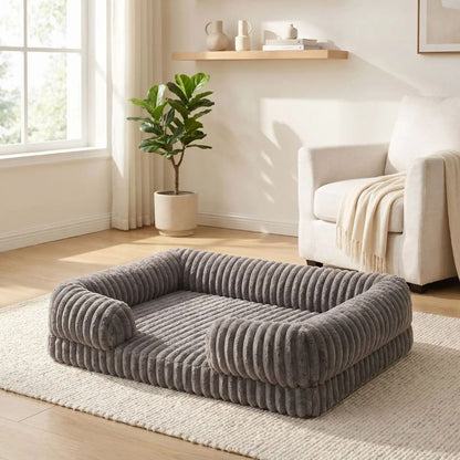 Panier-chien-déhoussable-design de canapé-antidérapant, imperméable et lavable en machine-housse en velours ultra-doux, résistant et chaud-rebord cylindrique entourant en U avec rembourrage 100% coton haute densité ergonomique-matelas orthopédique haute résilience du S au XL, de forme rectangulaire avec entrée devant pour chiot et chien de petite à grande de 0 à 40 kg – gros plan sur le panier entourant et apaisant de couleur marron de taille xl sur le sol du salon de l'appartement