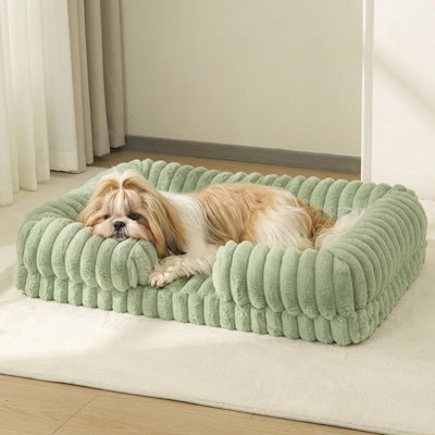 Panier-chien-déhoussable-design de canapé-antidérapant, imperméable et lavable en machine-housse en velours ultra-doux, résistant et chaud-rebord cylindrique entourant en U avec rembourrage 100% coton haute densité ergonomique-matelas orthopédique haute résilience du S au XL, de forme rectangulaire avec entrée devant pour chiot et chien de petite à grande de 0 à 40 kg – un chien de race moyenne qui dort paisiblement niché contre le rebord de son panier entourant, apaisant, anti stress de couleur vert clair