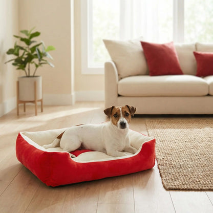 Panier-chien-lavable-chiot-design avec motif os, lavable en machien antidérapant avec rebord, coussin moelleux et ergonomique au rembourrage 100% coton haute densité de forme rectangulaire pour chien de petite à moyenne taille de 0 à 18 kilos max- un jchien de petite race couché confortablement dans le panier rouge et blanc avec son design os dans le salon de la maison