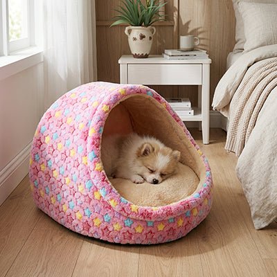 Panier-chien-niche-chiot-anti-anxiete-anti-stress avec coussin amovible déhoussable et lavable en machien, toucher velours, hypoallergénique et 100% coton haute densité avec motif étoiles en 3 coloris bleu, rose et marron pour les races de petits chiens, races naines et chiot-un chien de race Toy qui dort qui dort paisiblement dans sa niche en demi cercle entourante, antidérapante qui protège des sols froids et des courants d'air dans la chambre de la maison