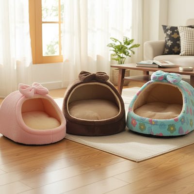 Panier-chien-niche-cocon-avec-coussin ergonomique et amovible, panier anti-stress 100% coton haute densité, lavable en machine, antidérapant avec toit , enveloppant, protège du sol froid et des courant d'air pour les chiots et chiens de race naine ou  petite taille de 0 à 5 kilos-gros plan sur les trois modèles de  panier niche de couleur rose, bleu et marron pour petit chien sur le sol du salon de l'appartement