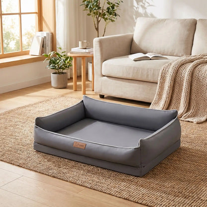 Panier-lavable-pour-chien-impermeable-4-saisons pour chiot, chien de petite, moyenne et grande taille du S au XL, avec matelas orthopédique à mémpoire de forme, déhoussable et lavable en machine, housse 100% imperméable en tissu solide et résistant, panier rectagulaire avec rebord surélevé et dossier plus haut pour un effet canapé lit pour chien-gros plan sur le panier confortable et ergonomique pour chien en taille L en couleur gris foncé sur le sol du salon de l'appartement