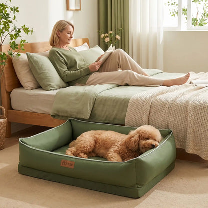Panier-lavable-pour-chien-impermeable-4-saisons pour chiot, chien de petite, moyenne et grande taille du S au XL, avec matelas orthopédique à mémpoire de forme, déhoussable et lavable en machine, housse 100% imperméable en tissu solide et résistant, panier rectagulaire avec rebord surélevé et dossier plus haut pour un effet canapé lit pour chien-un chien moyen qui dort paisiblement,sa tête posée sur le rebord rembourré 100% coton haute densité dans son  panier orthopédique au pied du lit de sa maîtresse 