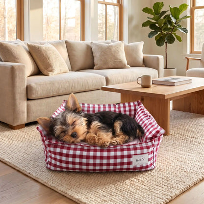 Panier-petit-chien-et-chiot-carreaux-vichy, 100% déhoussable,housse coton respirante 100% coton à carreaux vichy, coussin intérieur et 3 boudin au rembourrage 100% coton pour un panier confortable et ergonomique, anti-anxiété pour chiot chien de petite race et petite taille, disponible en 2 tailles XS et S-un yorkshire qui dort paisiblement dans son panier coussin rembourré avec rebords surélevés au rembourrage 100% coton haute densité avec motif carreaux vichy rouge et blanc sur le sol de l'appartement