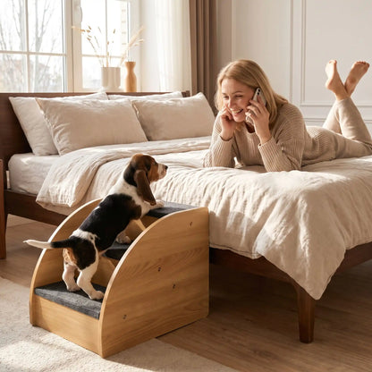 Petit-escalier-pour-chien et chiot design en bois-de chêne de 3 marches en tissu antidérapant noir, structure robuste et stable pourun accès facile au canapé, lit, etc., pour chiot et chien de petite taille- un chiot de race à pattes courtes qui montent en toute sécurité sur les marche en bois avec tissu antidérapant pour rejoindre facilement sa maitresse qui l'appelle pour qu'il vienne avec elle sur son lit dans la chambre de la maison
