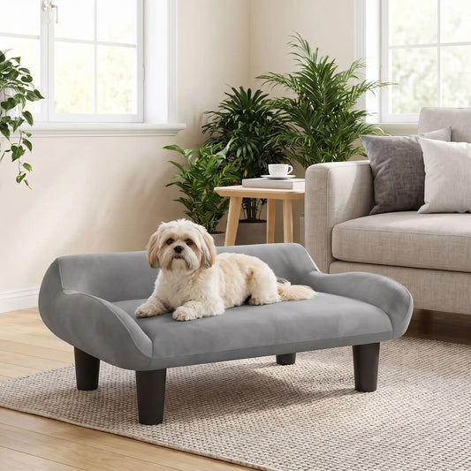 Petit-fauteuil-pour-chien-chiot-design de couleur gris, dossier et accoudoirs arrondis dans un style scandinave, velours résistant aux griffes,rembourrage 100% coton haute densité pour un confort optimal,structure en bois massif et surélevé avec 4 pieds en bois massif pour chiot et chien de 0 à 8 kilos-un chien de petite taille couché confortablement sur son canapé gris design sur pied en bois massif et rembourrage en éponge coton ergonomique dans le salon de la maison