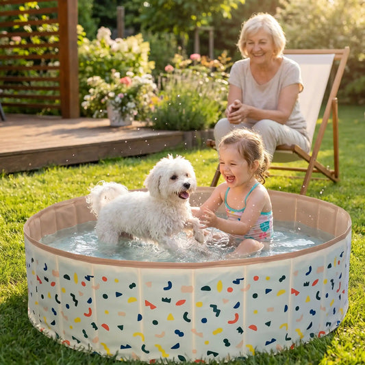Piscine-pour-chien-rigide en panneaux MDF robuste anti-affaissement, pliable et lavable de diamètre 120 cm et de 30 cm de hauteur étudié pour une entrée et sortie facile et sécurisé pour le chien avec bouchon de vidange pratique et rapide, polyvalente piscine à balle, bassin, baignoire pour toilettage-une petite fille assise dans la piscine qui jouent avec le petit chien qui se baigne avec bonheur sous le regard souriant de sa maitresse dans le jardin de la maison en été