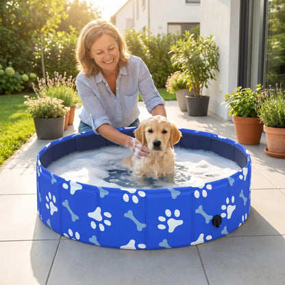 Piscine-rigide-pour-chien-rigide en panneaux MDF robuste anti-affaissement, pliable et lavable de diamètre 80 cm et de 20 cm de hauteur étudié pour une entrée et sortie facile et sécurisé pour le chien avec bouchon de vidange pratique et rapide, polyvalente piscine à balle, bassin, baignoire pour toilettage-un chiot qui se fait au toiletter dans sa piscine rigide pliable au design mignon de pattes et d'os blanc sur la terrasse de la maison en été