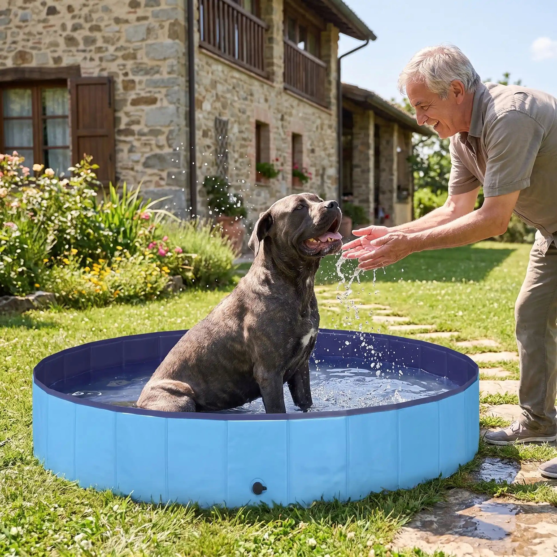 Piscine-pour-grand-chien-rigide-xxl, panneaux MDF robuste anti-affaissement, pliable et lavable de diamètre 200 cm et de 30 cm de hauteur étudiée pour une entrée et sortie facile et sécurisé pour le chien avec bouchon de vidange pratique et rapide, polyvalente piscine à balle, bassin, baignoire pour toilettage-un chien de grande race qui se rafraichit pour supporter la chaleur dans sa grande piscine robuste avec son maitre qui le mouille délicatement dans le jardin de la maison en été