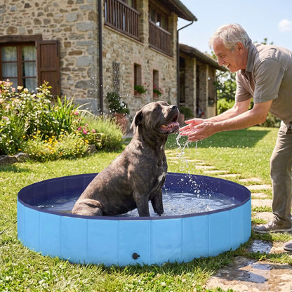 Piscine-pour-grand-chien-rigide-xxl, panneaux MDF robuste anti-affaissement, pliable et lavable de diamètre 200 cm et de 30 cm de hauteur étudiée pour une entrée et sortie facile et sécurisé pour le chien avec bouchon de vidange pratique et rapide, polyvalente piscine à balle, bassin, baignoire pour toilettage-un chien de grande race qui se rafraichit pour supporter la chaleur dans sa grande piscine robuste avec son maitre qui le mouille délicatement dans le jardin de la maison en été