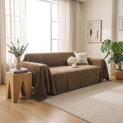 Protection-canape-chien--anti-poils-résistante aux griffes, tissage chenille coton et polyester, écoresponsable avec franges pour un style bohème chic de couleur marron, disponible en 4 tailles pour fauteuil/canapé une place, deux places, 3 places et 4 places, lavable en machine, doux respirant confortable et 4 saisons-gros plan sur le plaid de protection grande taille sur un canapé 4 palce complètement recouvert accoudoir et dossier, tissu souple et frangés pour une décoration lifestyle dans le salon 