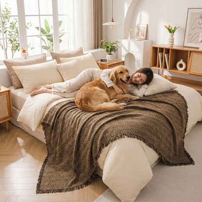 Protection-canape-chien--anti-poils-résistante aux griffes, tissage chenille coton et polyester, écoresponsable avec franges pour un style bohème chic de couleur marron, disponible en 4 tailles pour fauteuil/canapé une place, deux places, 3 places et 4 places, lavable en machine, doux respirant confortable et 4 saisons-un grand chien et sa maitresse allongés pour un câlin sur le plaid marron qui protège le lit de la chambre de la maison