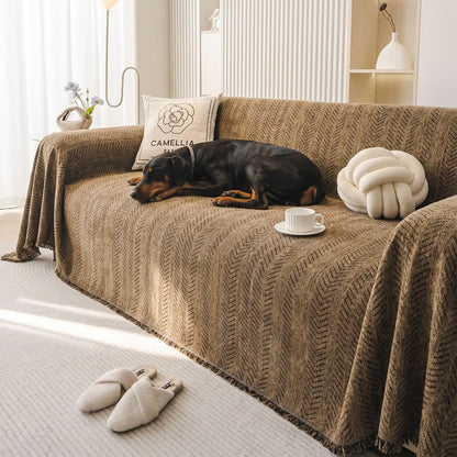 Protection-canape-chien--anti-poils-résistante aux griffes, tissage chenille coton et polyester, écoresponsable avec franges pour un style bohème chic de couleur marron, disponible en 4 tailles pour fauteuil/canapé une place, deux places, 3 places et 4 places, lavable en machine, doux respirant confortable et 4 saisons- un chien de grande race confortablement couché sur le plaid de protection qui couvre entièrement le grand canapé avec un style bohême chic avec son tissage solide artisanal