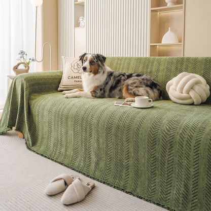 Protège-canapé-chien-anti-poils-résistante aux griffes, tissage chenille coton et polyester tissé résistant, écoresponsable avec franges pour un style bohème chic de couleur vert olive, disponible en 4 tailles pour fauteuil/canapé une place, deux places, 3 places et 4 places, lavable en machine, doux respirant confortable et 4 saisons-un chien de moyenne taille couché conofrtablement sur le protège canapé 4 places dans le salon de la maison